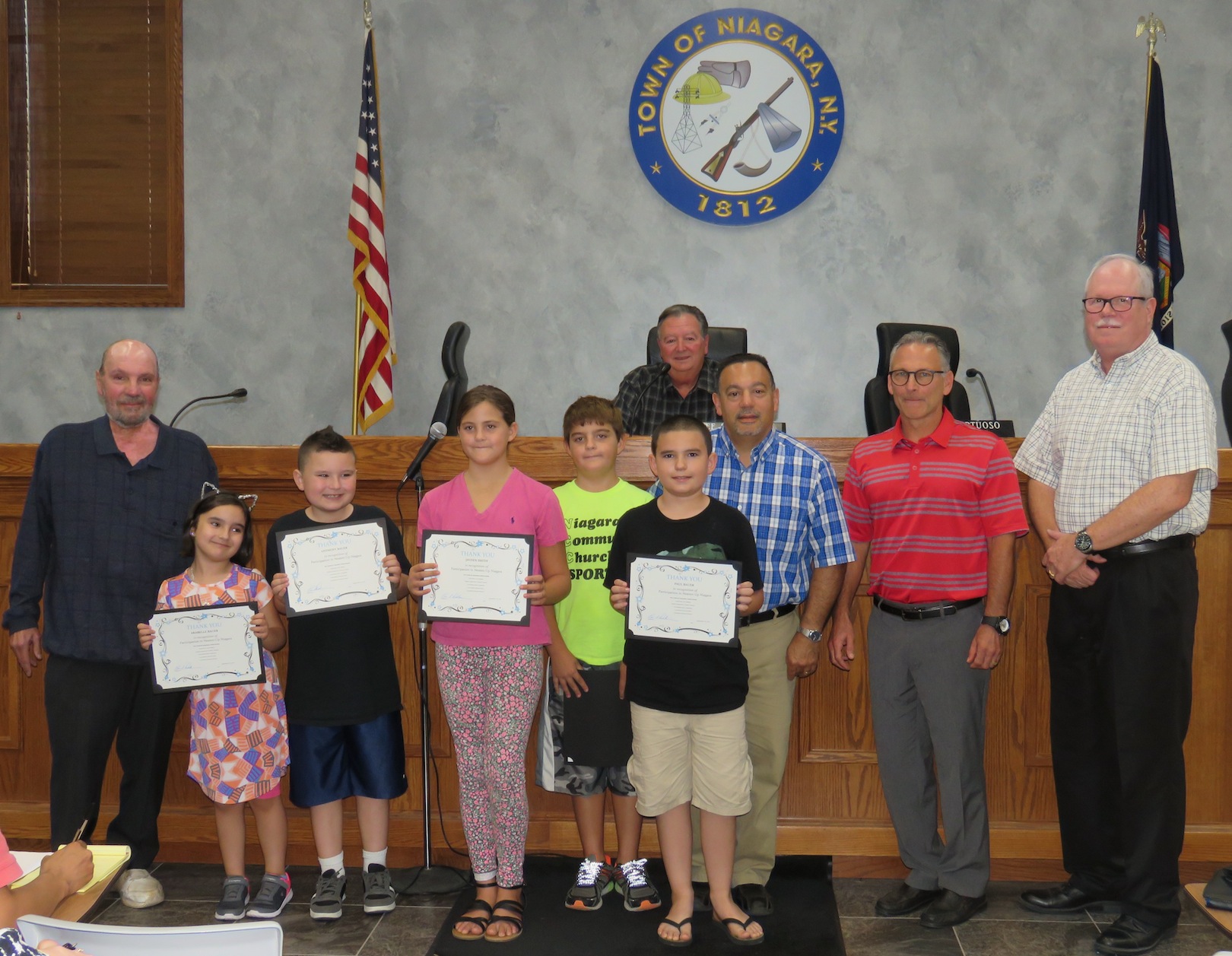Pictured are Jayden Smith, Aleczander Smith, Paul Bauer, Arabelle Bauer and Anthony Bauer with Town of Niagara Supervisor Lee Wallace and councilmen Rich Sirianni, Charles Teixeira, Sam Gatto and Marc Carpenter. (Photo by David Yarger)